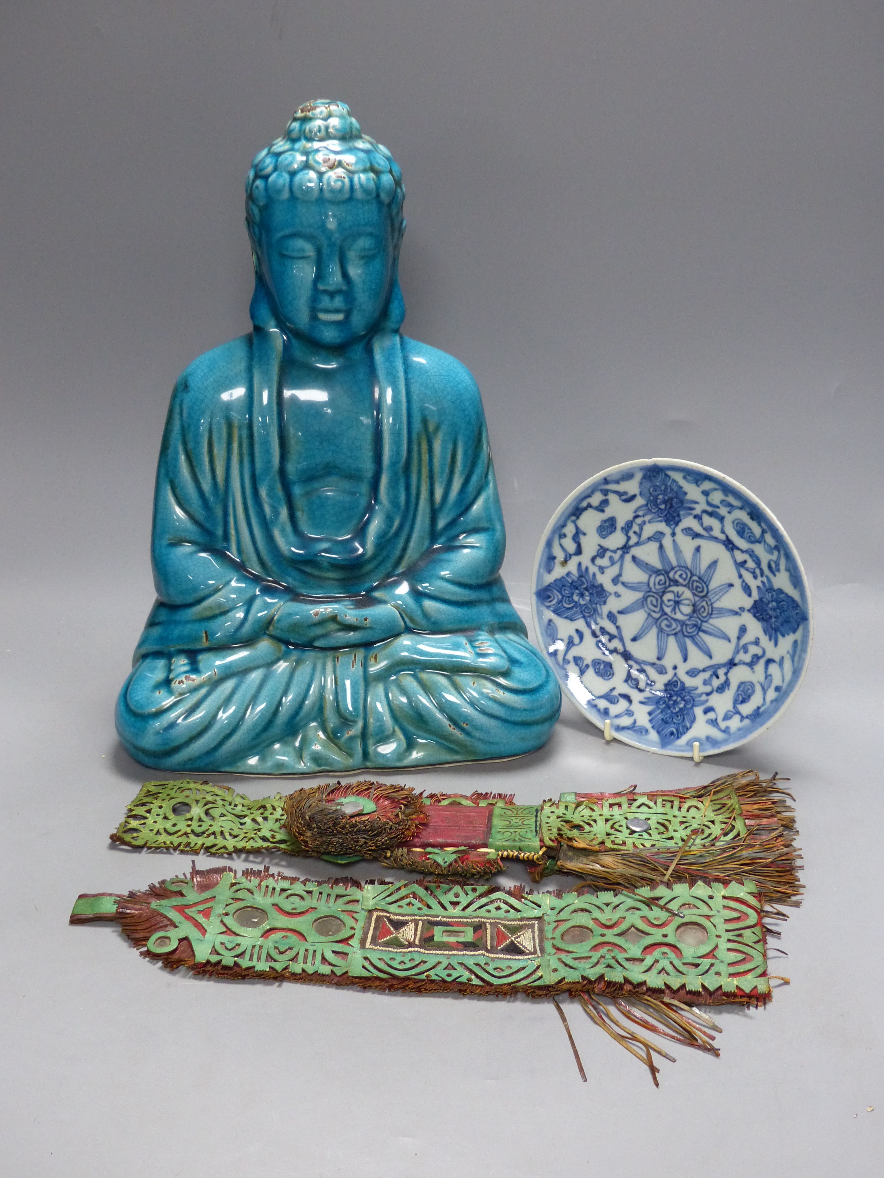 A Chinese ceramic buddha, height 40cm, a blue and white dish, and two leather wall hangings, Qing period or later